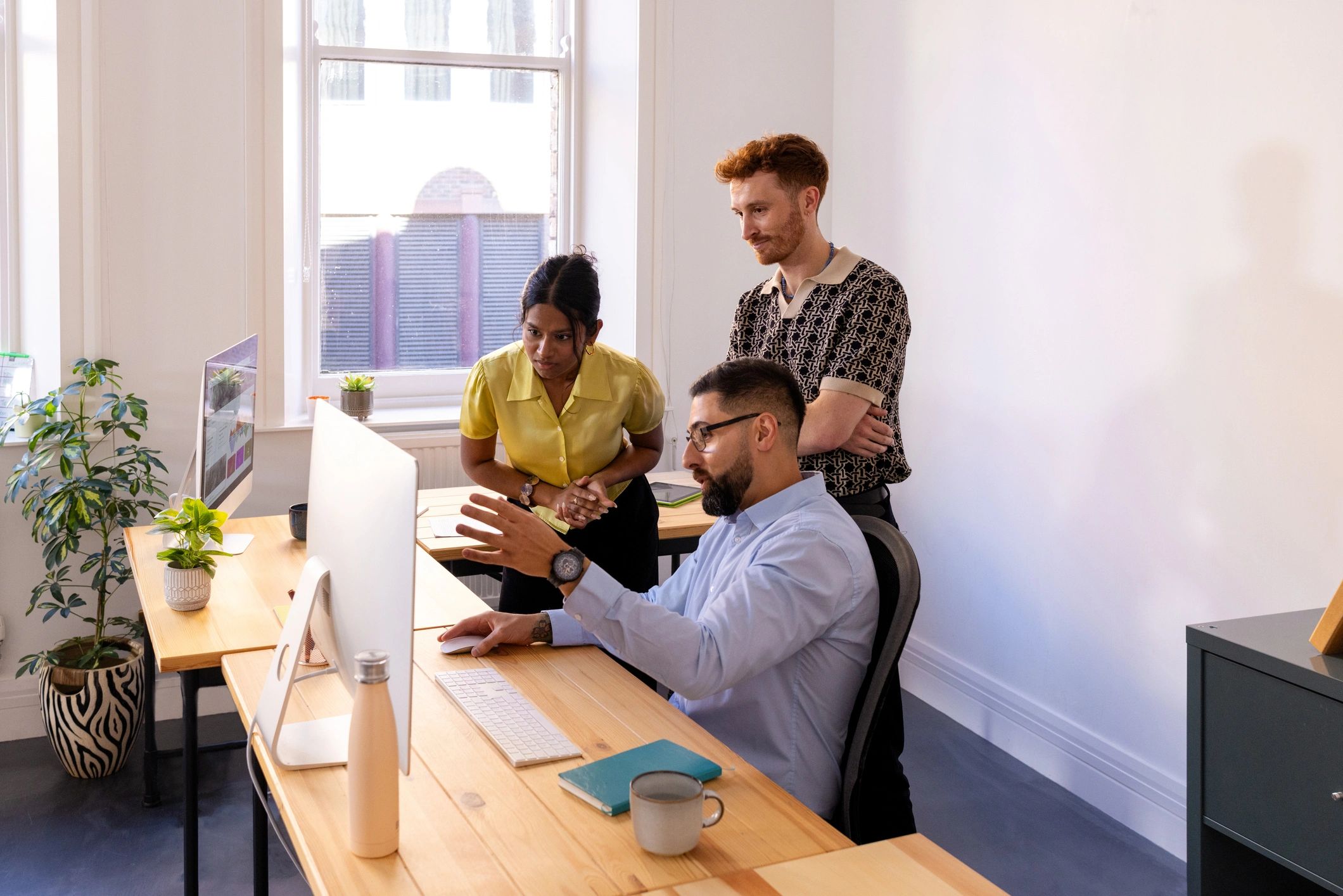 Colleagues reviewing work together at a computer